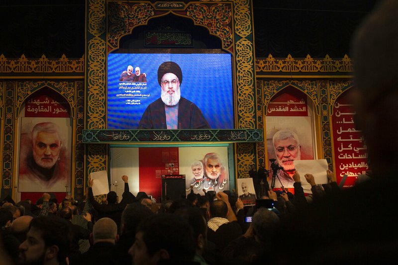 Supporters of Hezbollah leader Sayyed Hassan Nasrallah chant slogans as he makes televised remarks at a rally in a southern suburb of Beirut, Lebanon, Sunday, Jan. 5, 2020 following the U.S. airstrike in Iraq that killed Iranian Revolutionary Guard Gen. Qassem Soleimani, seen on a poster at left, and Iraqi Popular Mobilization forces commander Abu Mahdi al-Muhandis, who was also killed. Nasrallah called the killing of Soleimani a "clear, blatant crime" that will transform the Middle East. (AP Photo/Maya Alleruzzo)