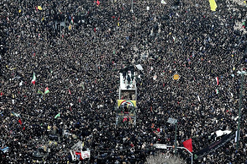 Coffins of Iranian Gen. Qassem Soleimani and others who were killed in Iraq by a U.S. drone strike are carried on a truck surrounded by mourners Sunday during a funeral procession in Mashhad, Iran. More photos at arkansasonline.com/16iran/.  