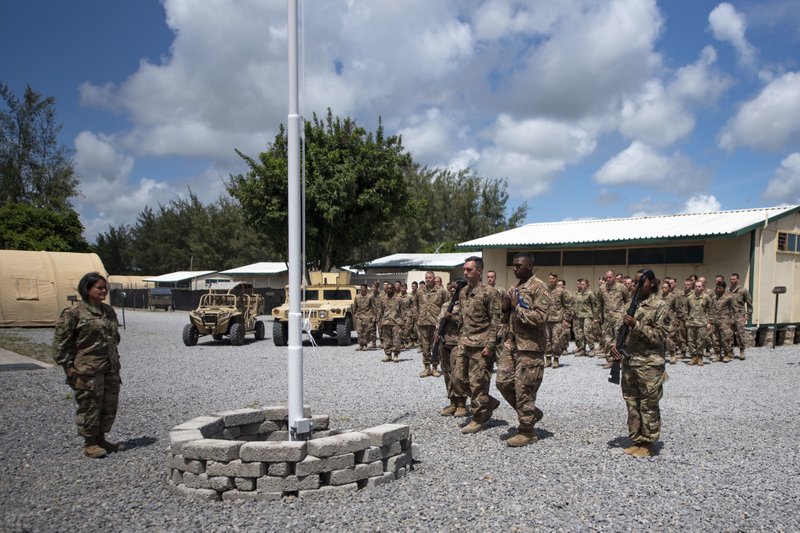 In this photo taken Aug. 26, 2019 and released by the U.S. Air Force, airmen from the 475th Expeditionary Air Base Squadron conduct a flag-raising ceremony, signifying the change from tactical to enduring operations, at Camp Simba, Manda Bay, Kenya. The al-Shabab extremist group said Sunday, Jan. 5, 2020 that it has attacked the Camp Simba military base used by U.S. and Kenyan troops in coastal Kenya, while Kenya's military says the attempted pre-dawn breach was repulsed and at least four attackers were killed. (Staff Sgt. Lexie West/U.S. Air Force via AP)