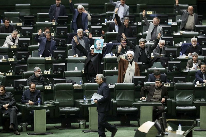 An Iranian lawmaker holds a portrait of slain Gen. Qassem Soleimani in an open session of parliament Tuesday in Tehran during debate on a bill declaring U.S. military leaders as terrorists. The measure was approved. More photos at arkansasonline.com/18iran/.
(AP/Vahid Salemi)