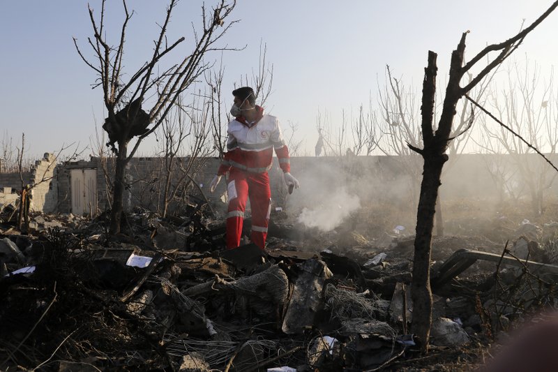 A rescue worker searches the scene where an Ukrainian plane crashed in Shahedshahr, southwest of the capital Tehran, Iran, Wednesday, Jan. 8, 2020. A Ukrainian airplane carrying 176 people crashed on Wednesday shortly after takeoff from Tehran's main airport, killing all onboard. (AP Photo/Ebrahim Noroozi)

