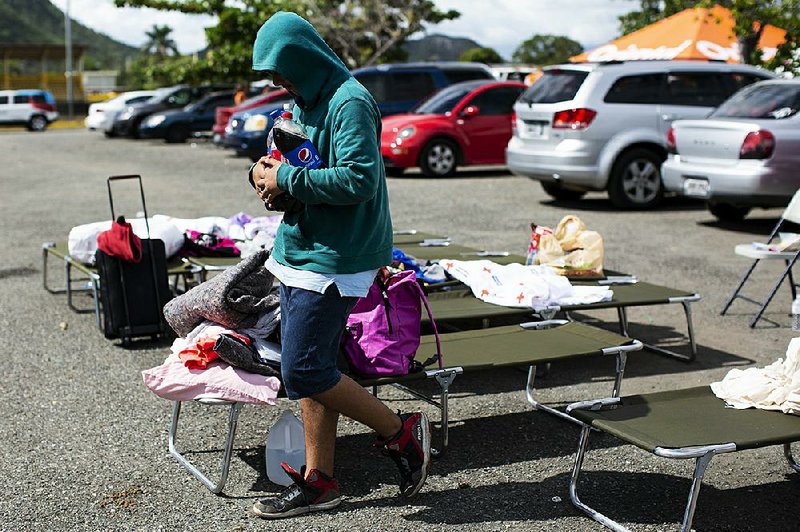 An earthquake refugee walks through cots Wednesday outside a gymnasium in Guanica in southwest Puerto Rico. More than 2,000 people who had taken shelter inside Monday were forced to sleep outside after the latest aftershock made the structure unstable. More photos at arkansasonline.com/19quake/.
(The New York Times/Erika P. Rodriguez)