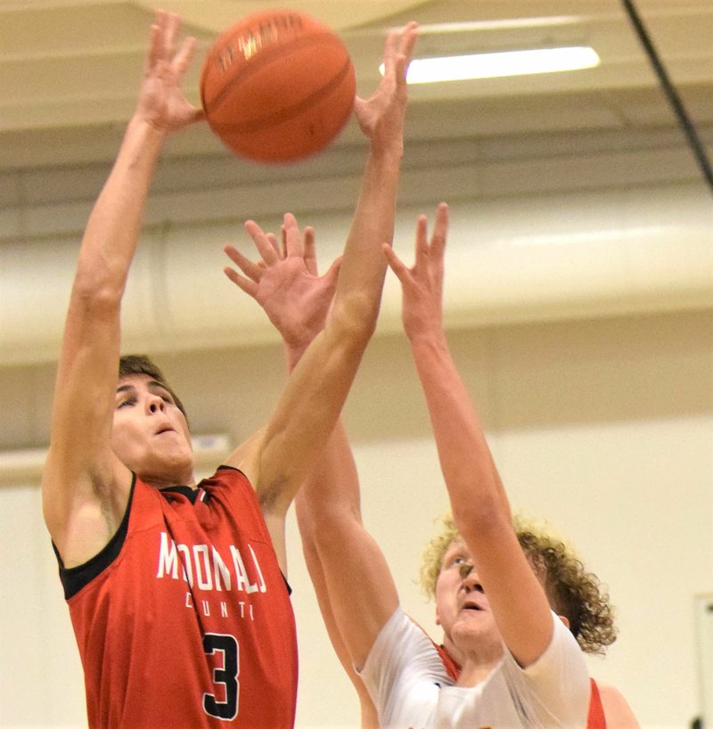 RICK PECK/SPECIAL TO MCDONALD COUNTY PRESS McDonald County's Cale Adamson blocks out Monett's Arijan Miftari for a rebound during the 65th Annual Neosho Holiday Classic held from Dec. 26-28 at Neosho High School and Neosho Middle School. Monett rebounded from a 10-point deficit in the third quarter for a 61-53 win.