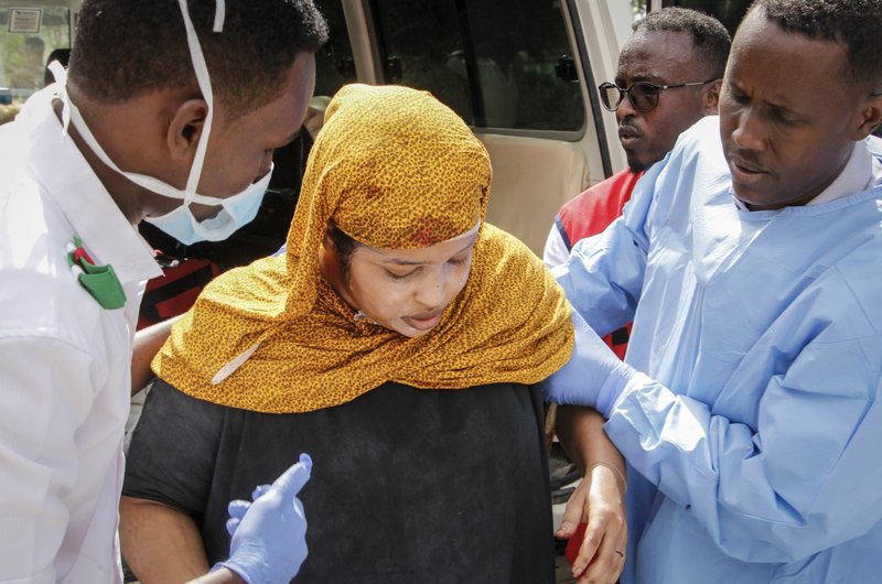 Medics help a woman who was wounded in a vehicle bomb attack on a security checkpoint located near the presidential palace, as she arrives at a hospital in Mogadishu, Somalia, Wednesday, Jan. 8, 2020. (AP Photo/Farah Abdi Warsameh)