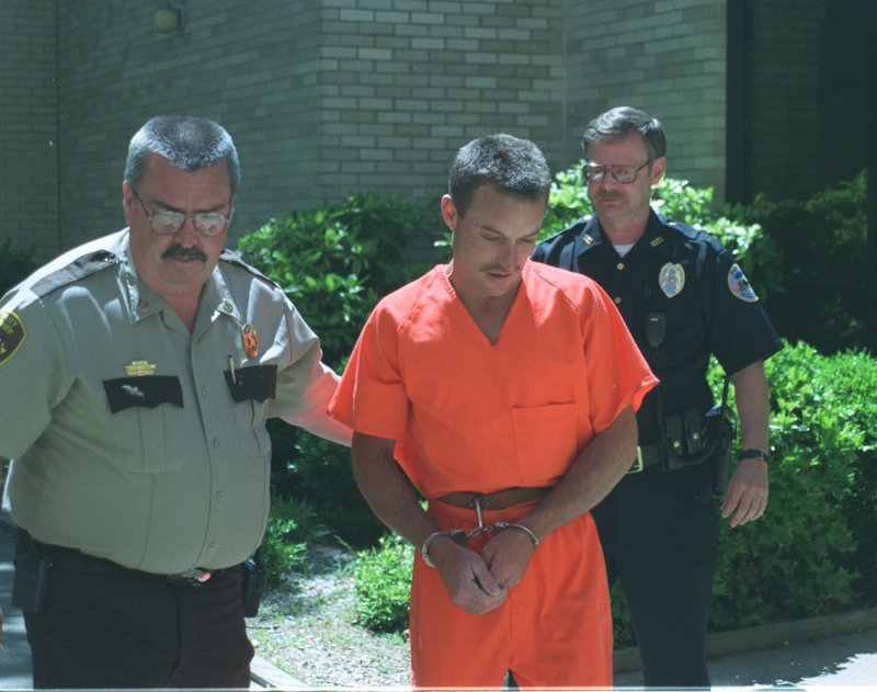 In this May 1999 file photo, Polk County Sheriff's officer and a member of the Mena Police Department lead Karl Roberts from the Polk County Detention Center to the Polk County Courthouse.
(Arkansas Democrat-Gazette/KAREN E. SEGRAVE)