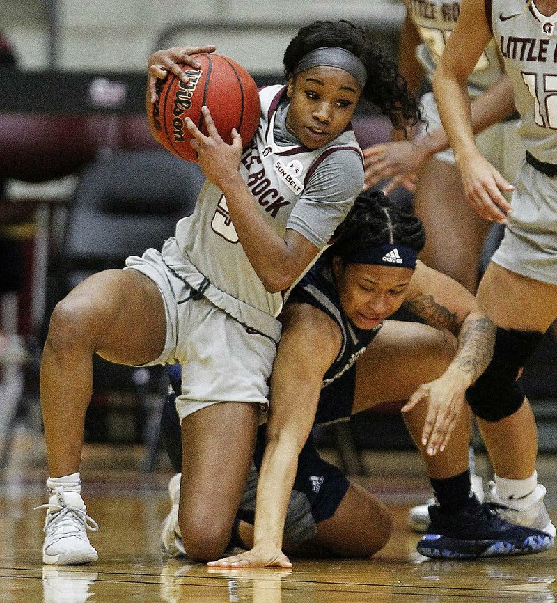 UALR junior guard Tori Lasker (left) swipes the ball from Georgia Southern senior guard Alexis Brown during the Trojans’ victory over the Eagles on Thursday night at the Jack Stephens Arena in Little Rock. See more photos at arkansasonline.com/110ualrwb.