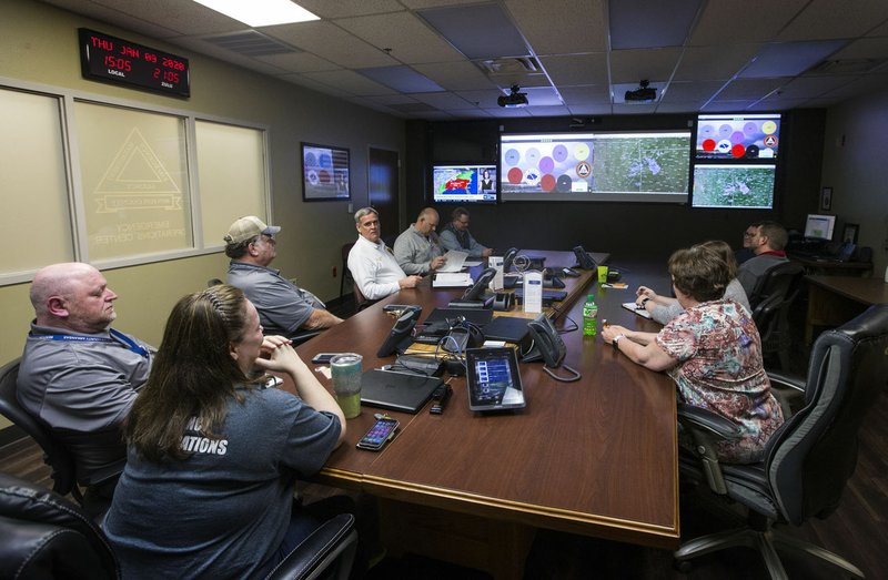 Representatives from multiple Benton County and municipal agencies gather Thursday at the Emergency Operations Center in the Benton County Administration Building. The group participated in a webinar briefing by the National Weather Service in Tulsa, Okla., about the severe weather forecast for today and Saturday. Go to nwaonline.com/photos to see more photos. (NWA Democrat-Gazette/Ben Goff)