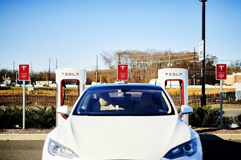 A Tesla electric vehicle sits at a charging station in North Brunswick, N.J., late last year. States where electric vehicles are increasing in popularity are looking at ways to boost power production for the vehicles. 