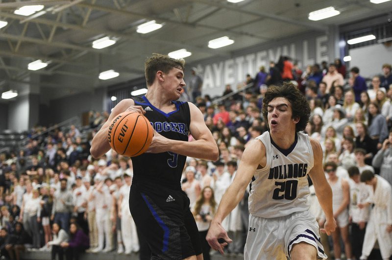 Rogers Karsen Uecker (5) protects the ball from Fayetteville forward Matt Wayman (20) during a basketball game, Friday, January 10, 2020 at Fayetteville High School in Fayetteville. Check out nwaonline.com/200111Daily/ for today&#x2019;s photo gallery. (NWA Democrat-Gazette/Charlie Kaijo)