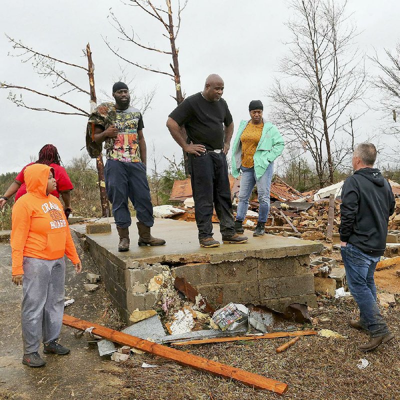Pickens County, Ala., Sheriff Todd Hall (right) talks with Larry Jones (center) and other residents of an area near Carrollton, Ala., that was devastated by a tornado that tore through Saturday, killing at least three people, officials said. More photos at arkansasonline.com/112winter/.  