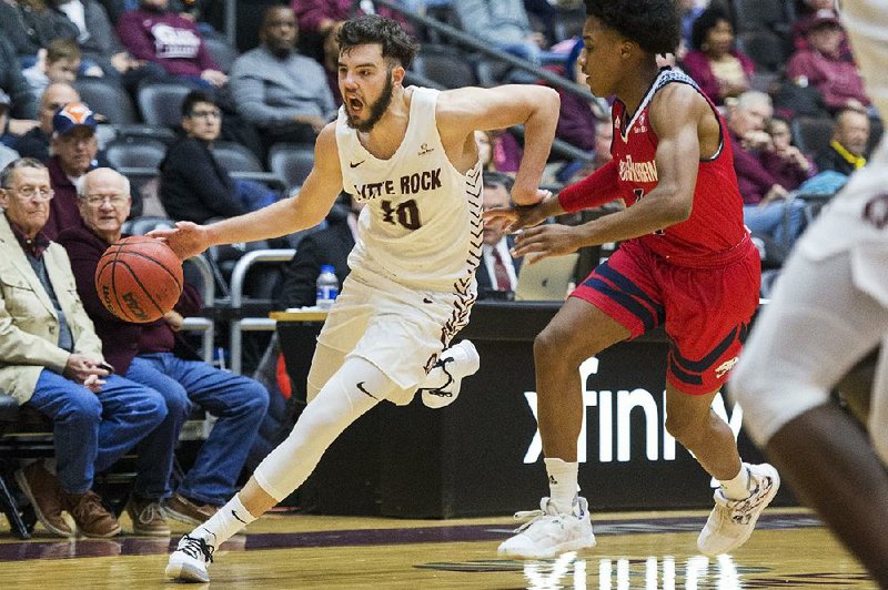 UALR guard Marko Lukic (10) dribbles past a South Alabama defender on his way to the basket Saturday during the Trojans’ 52-43 loss to the Jaguars at the Jack Stephens Center. More photos are available at arkansasonline.com/112usaatualrmbb/.