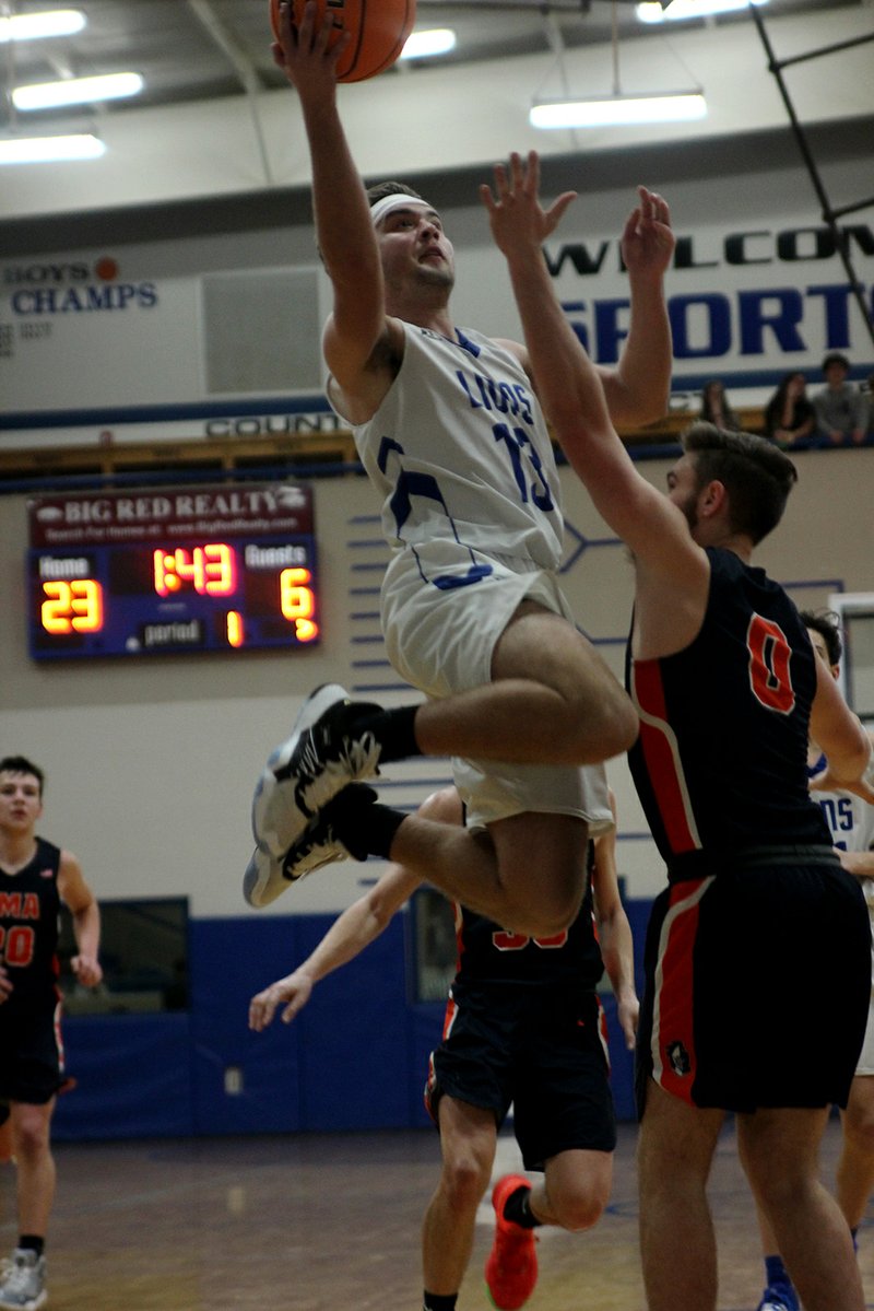 Jessieville junior Charlie Davis (13) goes up for a layup as Christian Ministries senior Jake Tankersley (0) defends in Friday&#x2019;s game at Jessieville Sports Arena. - Photo by James Leigh of The Sentinel-Record