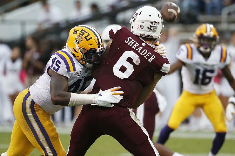 LSU linebacker Michael Divinity (left) pressures Mississippi State quarterback Garrett Shrader into rushing a pass during an Oct. 19 game in Starkville, Miss. Divinity is looking to put past troubles behind him as he helps LSU compete for the College Football Playoff title tonight against Clemson. 
