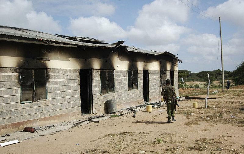 A member of Kenya’s security forces walks past a police post that was damaged in Monday’s attack by al-Shabab extremists in Kamuthe.