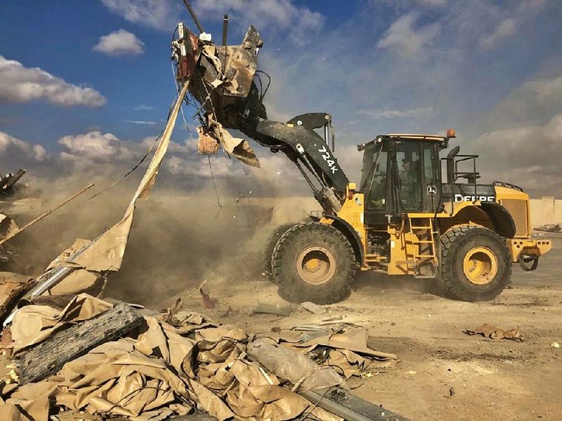 A bulldozer clears rubble and debris Monday at Ain al-Asad air base in Iraq. Video available at arkansasonline.com/114iran 