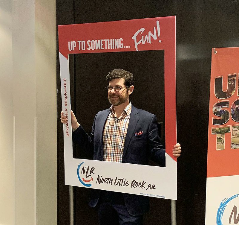 David Allred, a representative with the Stamp Idea Group of Montgomery, Ala., shows off the new logo unveiled Monday by the North Little Rock Convention and Visitors Bureau.  
