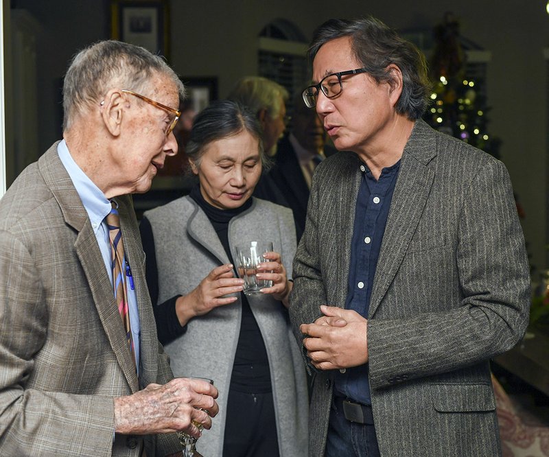 Don Munro, left, speaks with artist Longhua Xu, right, and his wife Shunying Chen during a fundraising party for "The Explorer" sculpture Xu will complete for the Gateway Project at the home of local philanthropist Dorothy Morris on Thursday. - Photo by Grace Brown of The Sentinel-Record