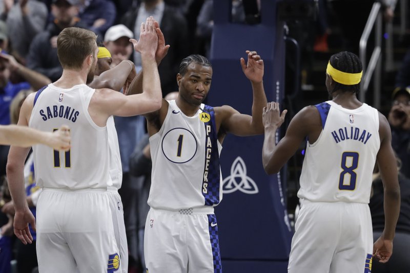 Indiana Pacers' T.J. Warren (1) is congratulated on blocking the shot of Philadelphia 76ers' Tobias Harris by Domantas Sabonis (11) and Justin Holiday (8) during the second half of Monday's game in Indianapolis. Indiana won 101-95. - Photo by Darron Cummings of The Associated Press story.lead_photo.caption