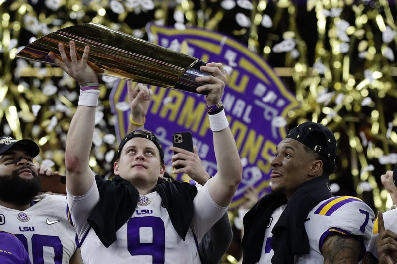 LSU quarterback Joe Burrow holds the trophy as safety Grant Delpit looks on after a NCAA College Football Playoff national championship game against Clemson, Monday, Jan. 13, 2020, in New Orleans. LSU won 42-25. (AP Photo/Sue Ogrocki) story.lead_photo.caption