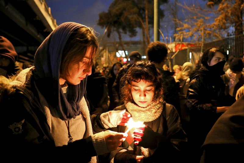People gather for a candlelight vigil to remember the victims of the Ukraine plane crash, at the gate of Amri Kabir University that some of the victims of the crash were former students of, in Tehran, Iran, Saturday, Jan. 11, 2020. Iran on Saturday, Jan. 11, acknowledged that its armed forces "unintentionally" shot down the Ukrainian jetliner that crashed earlier this week, killing all 176 aboard, after the government had repeatedly denied Western accusations that it was responsible. (AP Photo/Ebrahim Noroozi) story.lead_photo.caption