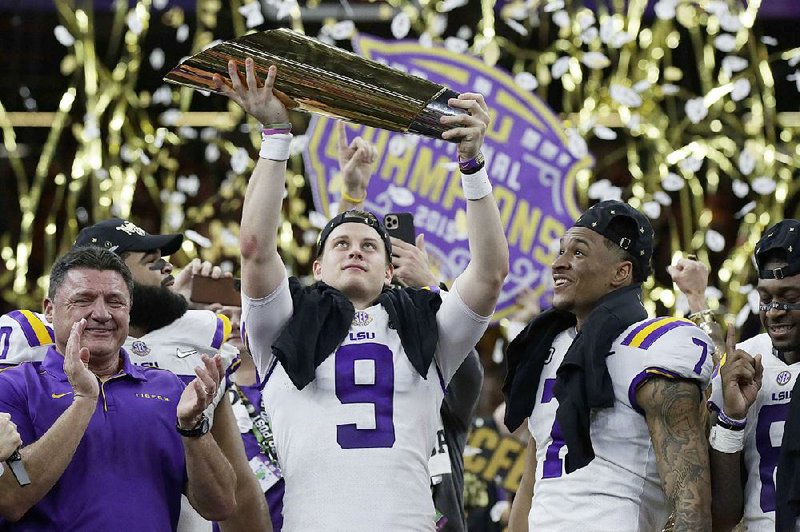 LSU quarterback Joe Burrow holds up the trophy as LSU celebrates after defeating Clemson 42-25 to win the College Football Playoff championship on Monday at Mercedes-Benz Superdome in New Orleans. Burrow threw for 463 yards and five touchdowns, setting an NCAA single-season record with 60 as LSU snapped defending national champion Clemson’s 29-game winning streak.