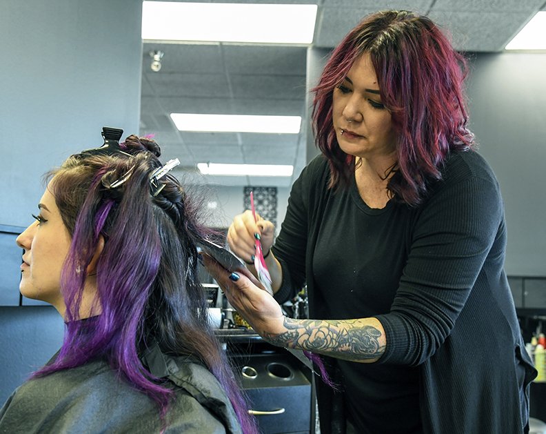 Local stylists Melanie Efird bleaches a client's hair at Curl Up and Dye salon. 