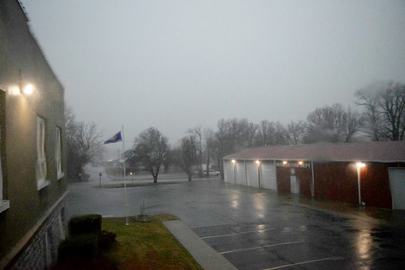 Westside Eagle Observer/MIKE ECKELS Dark skies move over city hall and fire station one in Decatur Jan. 10 as a severe thunderstorm with weak rotation prompted the sounding of the tornado sirens in the area.