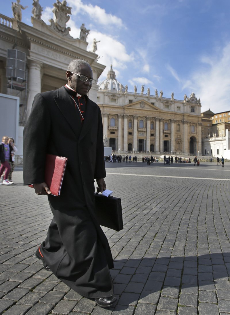 In this Monday, March 4, 2013 file photo, Cardinal Robert Sarah, of Guinea, walks in St. Peter's Square after attending a cardinals' meeting, at the Vatican. Retired Pope Benedict XVI wrote the book, "From the Depths of Our Hearts: Priesthood, Celibacy and the Crisis of the Catholic Church," along with his fellow conservative, Guinean Cardinal Robert Sarah, who heads the Vatican's liturgy office and has been a quiet critic of Francis. (AP Photo/Andrew Medichini, File)