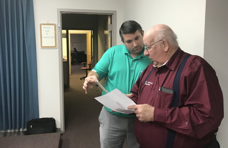 Election Commission Chairman Michael Adam (right) and Election Administrator Sven Hipp examine the early and absentee vote totals Tuesday night after the polls closed in the White Hall School District millage election.