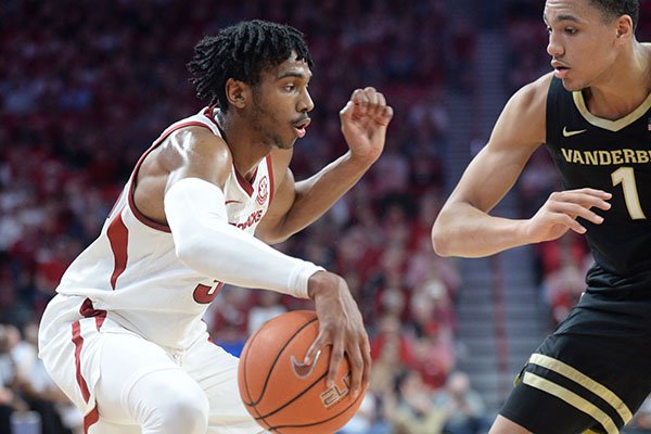 Arkansas guard Jimmy Whitt Jr. (left) looks to drive Wednesday, Jan. 15, 2020, as he is pressured by Vanderbilt forward Dylan Disu (1) during the first half in Bud Walton Arena.
