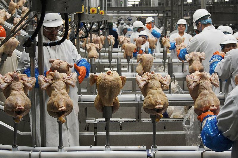 Workers process chickens last month at the Lincoln Premium Poultry plant in Fremont, Neb. Wholesale chicken prices rose in December. A big drop in beef prices kept down overall food costs, which fell 0.2%.
(AP/Nati Harnik)
