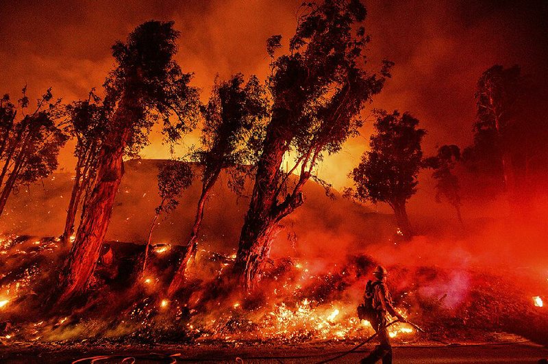 Flames from a backfire consume a hillside as firefighters deal with a wildfire in Santa Paula, Calif., in November, at the end of Earth’s hottest decade on record. Several scientists say the coming years will be even hotter.
(AP/Noah Berger)