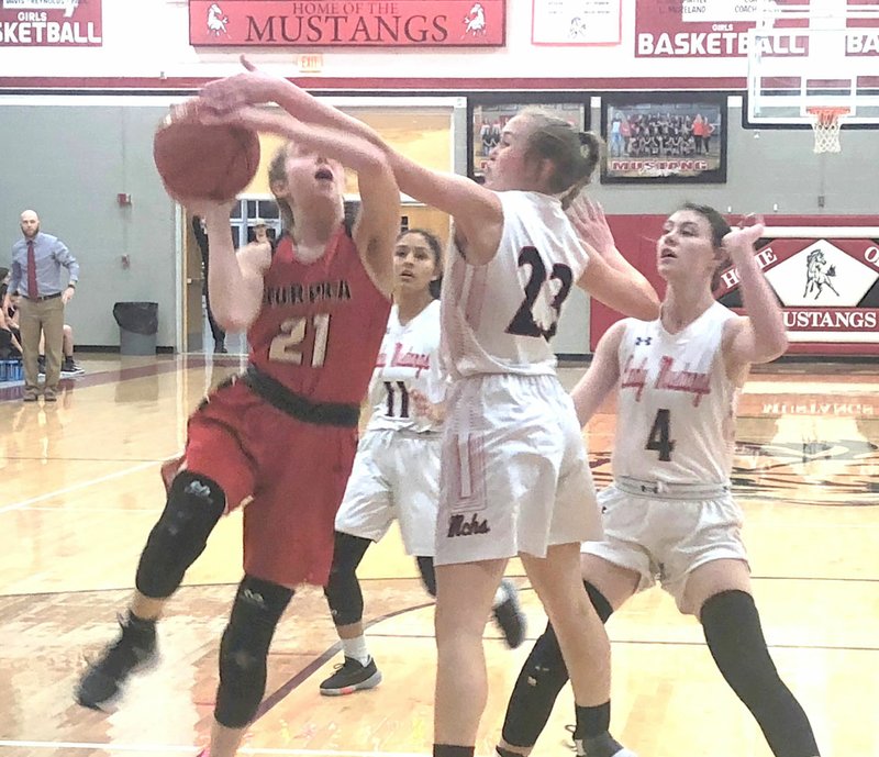 RICK PECK/SPECIAL TO MCDONALD COUNTY PRESS McDonald County's Kristin Penn gets a hand on the ball as Aurora's Elizabeth Martin goes in for a layup during the Lady Mustangs 48-45 win on Jan. 10 at MCHS.