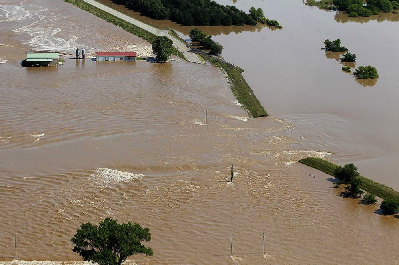 Water from the Arkansas River pours through a breach in the levee south of Dardanelle on May31. The Arkansas Natural Resources Commission approved a $1.5 million grant Thursday to fill a 30-foot hole and above-ground gap in the levee that occurred during the flooding. 