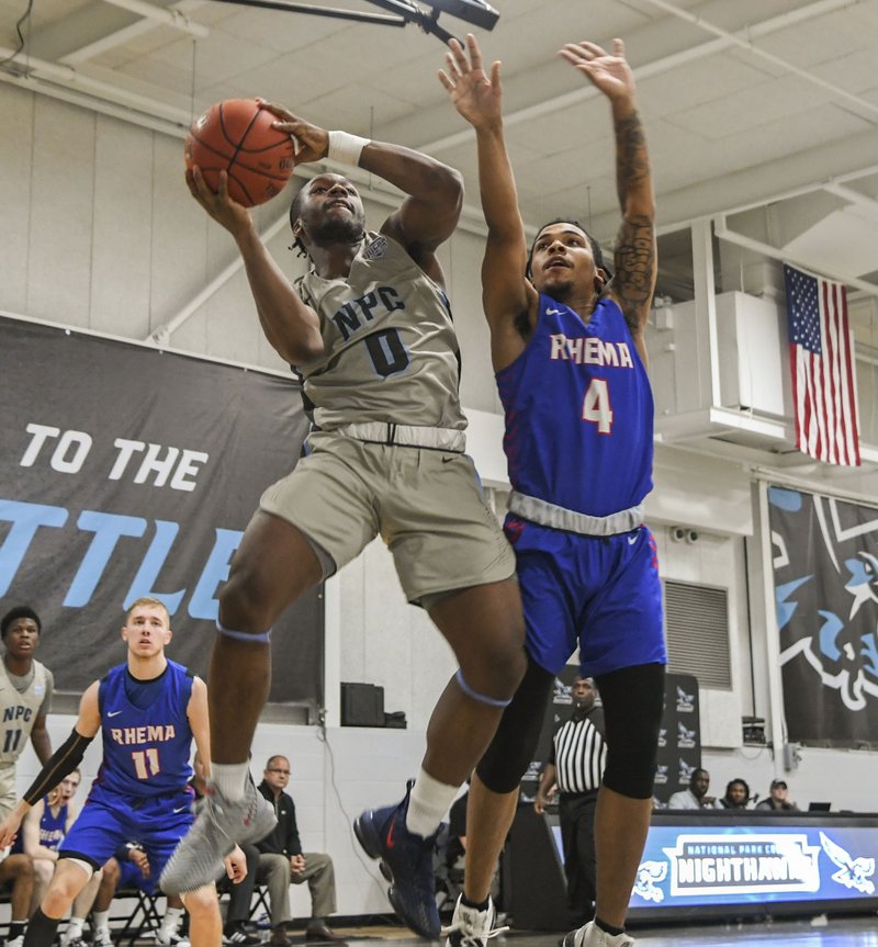 National Park College's Kamryn Vick (0) goes up for a basket as Rhema Bible College's Tyree Malone (4) defends during Wednesday's game at National Park. - Photo by Grace Brown of The Sentinel-Record