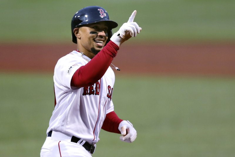 FILE - In this April 30, 2019, file photo, Boston Red Sox's Mookie Betts smiles as he crosses home plate on his solo home run off Oakland Athletics starting pitcher Aaron Brooks in the first inning of a baseball game at Fenway Park in Boston. Betts and the Red Sox agreed Friday, Jan. 10, 2020, to a $27 million contract, the largest one-year salary for an arbitration-eligible player. (AP Photo/Charles Krupa, File)