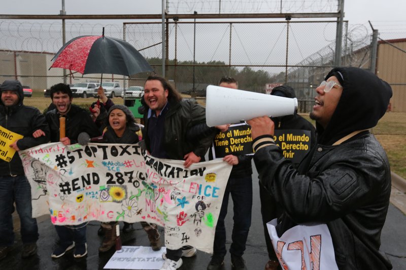 Kevin Rodriguez leads a chant Friday, January 17, 2020, with demonstrators in front of the Washington County Sheriff's Office in Fayetteville. Rodriguez was demonstrating for his older brother Alan.