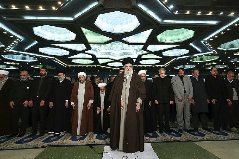 Iranian Supreme Leader Ayatollah Ali Khamenei (center) leads Friday prayers at a mosque in Tehran for the first time in eight years, using the moment to criticize Western countries and insist Iran would not bow to pressure from “American clowns.” Video at arkansasonline.com/118leader/.
(AP/Office of the Iranian Supreme Leader)