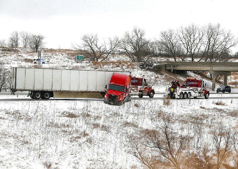 A jackknifed tractor-trailer forced the rerouting of traffic Friday on Interstate 80 near Adel, Iowa, as icy conditions wreaked havoc in the Midwest region.
(AP/The Des Moines Register/Bryon Houlgrave)