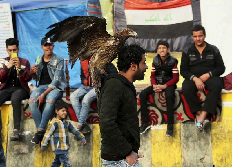 Protesters stage a sit-in Friday at Tahrir Square in Baghdad. Other protests in the city were violent.
(AP/Hadi Mizban)