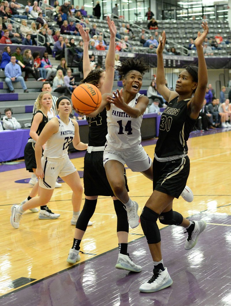 Fayetteville's Coriah Beck (14) reaches to score Friday, Jan. 17, 2020, over Bentonville's Maryam Dauda (right) and Bella Irlenborn during the first half of play in Bulldog Arena in Fayetteville. Visit nwaonline.com/prepbball/ for a gallery from the games. (NWA Democrat-Gazette/Andy Shupe)
