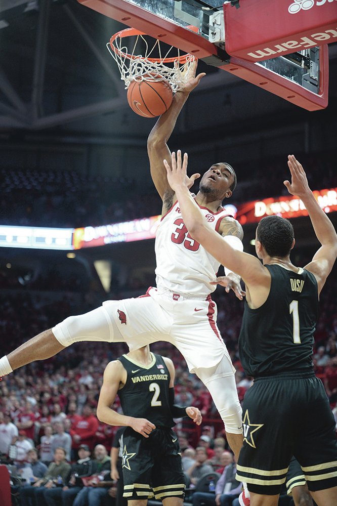 Arkansas guard Jimmy Whitt Jr. (33) dunks the ball Wednesday over Vanderbilt forward Dylan Disu (1) during the first half in Bud Walton Arena. - Photo by Andy Shupe of the NWA Democrat-Gazette