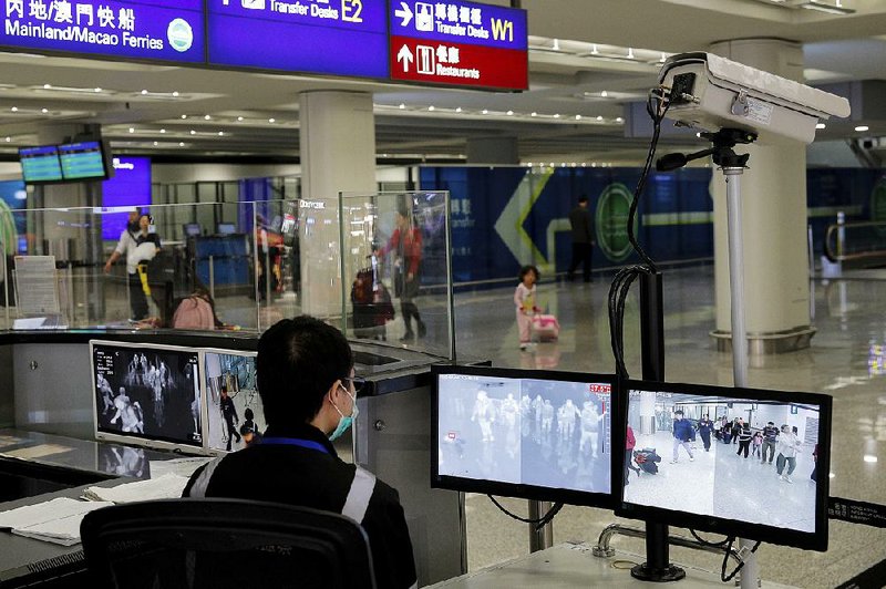 A health surveillance officer monitors passengers arriving at Hong Kong International Airport earlier this month.  