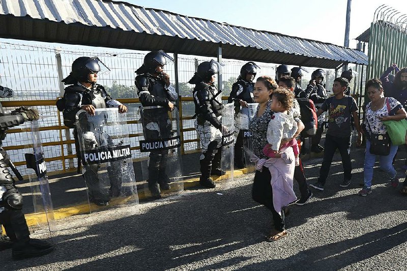 Honduran migrants cross the border Saturday into Ciudad Hidalgo, Mexico. More photos at arkansasonline.com/119guatemala/.  