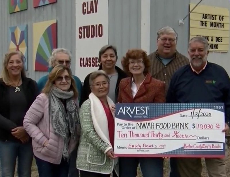 On Jan. 2, artists of the Clay Studio at Wishing Spring Gallery in Bella Vista presented a check for $10,030 to the Northwest Arkansas Food Bank. The funds were raised during the club's first Empty Bowl fundraiser where seven artists created 500 clay soup bowls, sold them for $20 each during October and November of last year and hosted a soup bowl luncheon at St. Theodore's Church on Nov. 14. The artists' intent was to raise $10,000 for the hungry of Northwest Arkansas, and they are elated that this first effort produced more than the goal. In the back row are Sue Hacker (from left), Phil Calkins, Margaret Rost and Dave Johnson; front row: Roz Ramey, Nori Allen, Heather Grills and CEO of the Food Bank Kent Eikenberry. (Courtesy Photo)