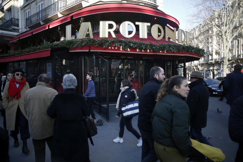People walk past the restaurant La Rotonde, in Paris, Saturday, jan.18, 2020. The Paris prosecutor's office says it has opened an investigation to determine the causes of the Rotonde fire. (AP Photo/Thibault Camus)
