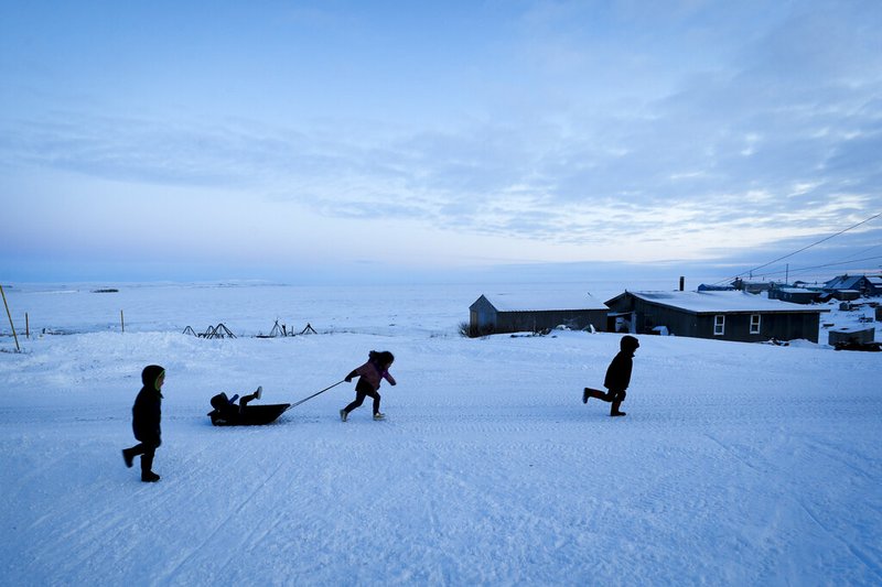 Children play in the snow Saturday, Jan. 18, 2020, in Toksook Bay, Alaska. The first Americans to be counted in the 2020 Census starting Tuesday, Jan. 21, live in this Bering Sea coastal village. The Census traditionally begins earlier in Alaska than the rest of the nation because frozen ground allows easier access for Census workers, and rural Alaska will scatter with the spring thaw to traditional hunting and fishing grounds. (AP Photo/Gregory Bull)