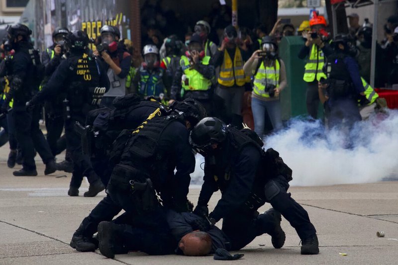 Police detain protesters calling for electoral reforms and a boycott of the Chinese Communist Party in Hong Kong, Sunday, Jan. 19, 2020. Hong Kong has been wracked by often violent anti-government protests since June, although they have diminished considerably in scale following a landslide win by opposition candidates in races for district councilors late last year. (AP Photo/Ng Han Guan)