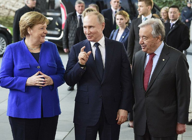 German Chancellor Angela Merkel (left) greets Russian President Vladimir Putin (center) and United Nations Secretary General Antonio Guterres after their arrival Sunday for a conference on Libya at the chancellery in Berlin. More photos at arkansasonline.com/120libya/.  