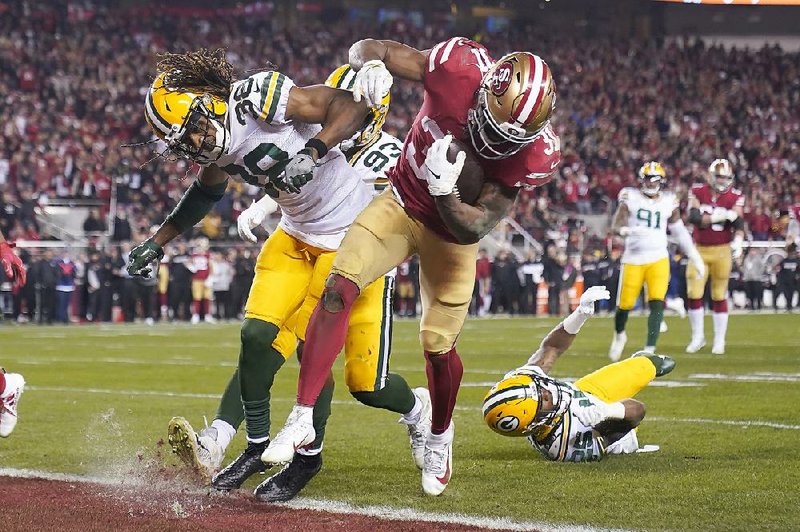 San Francisco 49ers running back Raheem Mostert scores a touchdown past Green Bay Packers cornerback Tramon Williams during the second half of the NFC Championship Game on Sunday in Santa Clara, Calif. Mostert’s four rushing touchdowns paved the way for the 49ers to win 37-20.